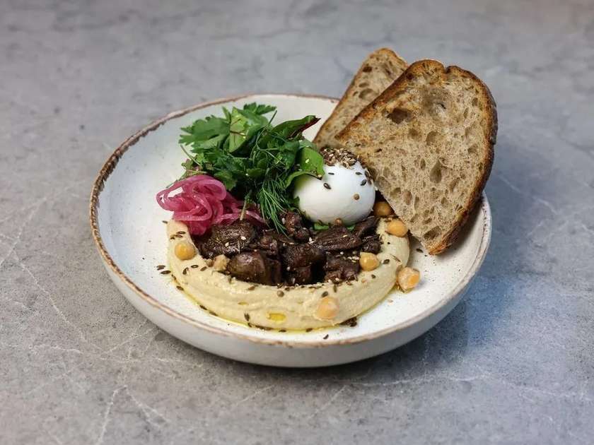 Східний сніданок з качиним серцями, хумусом і яйцем пашот