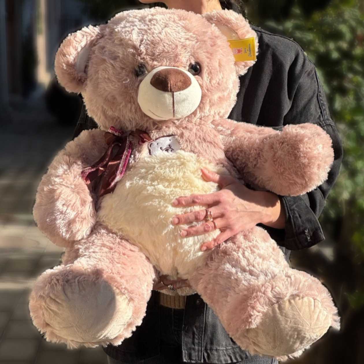 Soft toy teddy bear with dark cherry bow