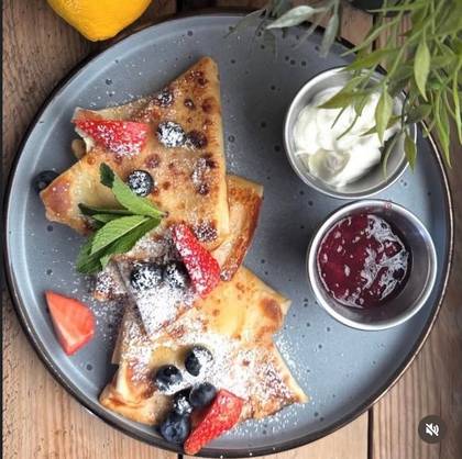 Thin pancakes with jam and sour cream