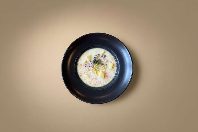 Homemade fish soup with melted cheese