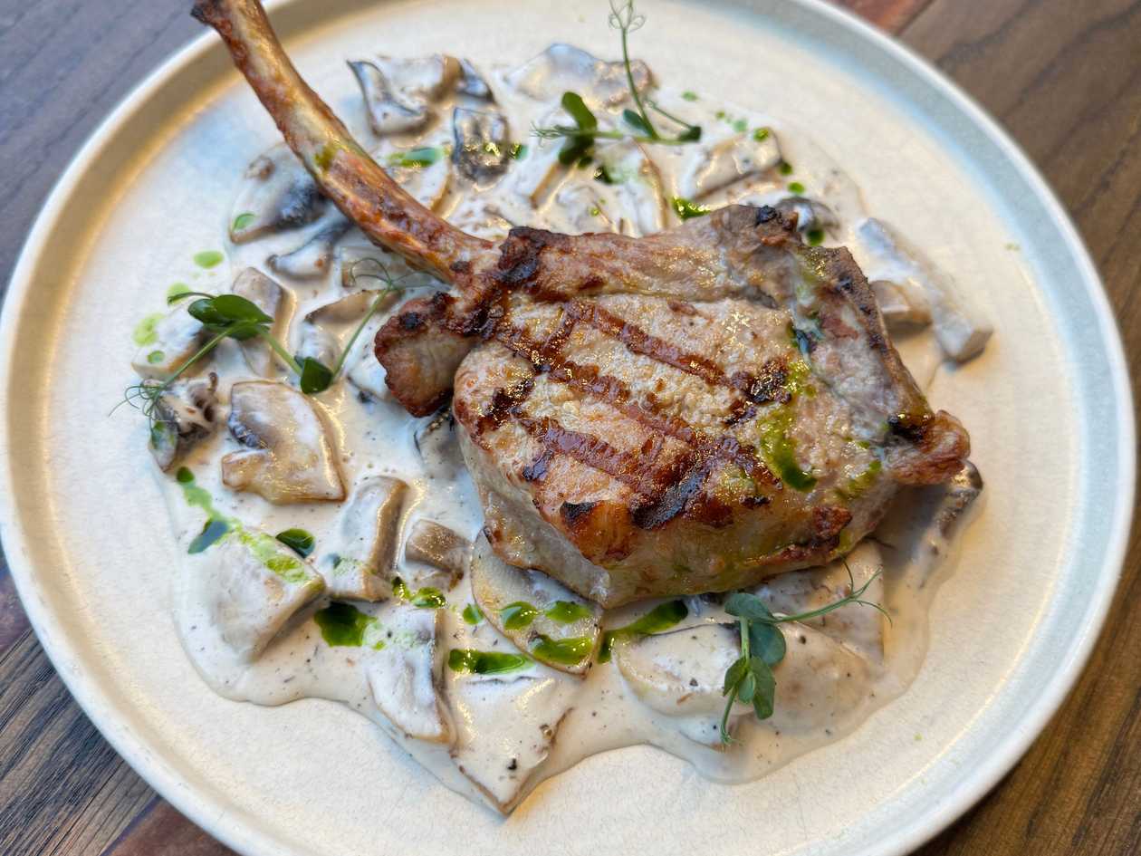 Tomahawk de porc cu ciuperci și cartofi prăjiți cu parmezan