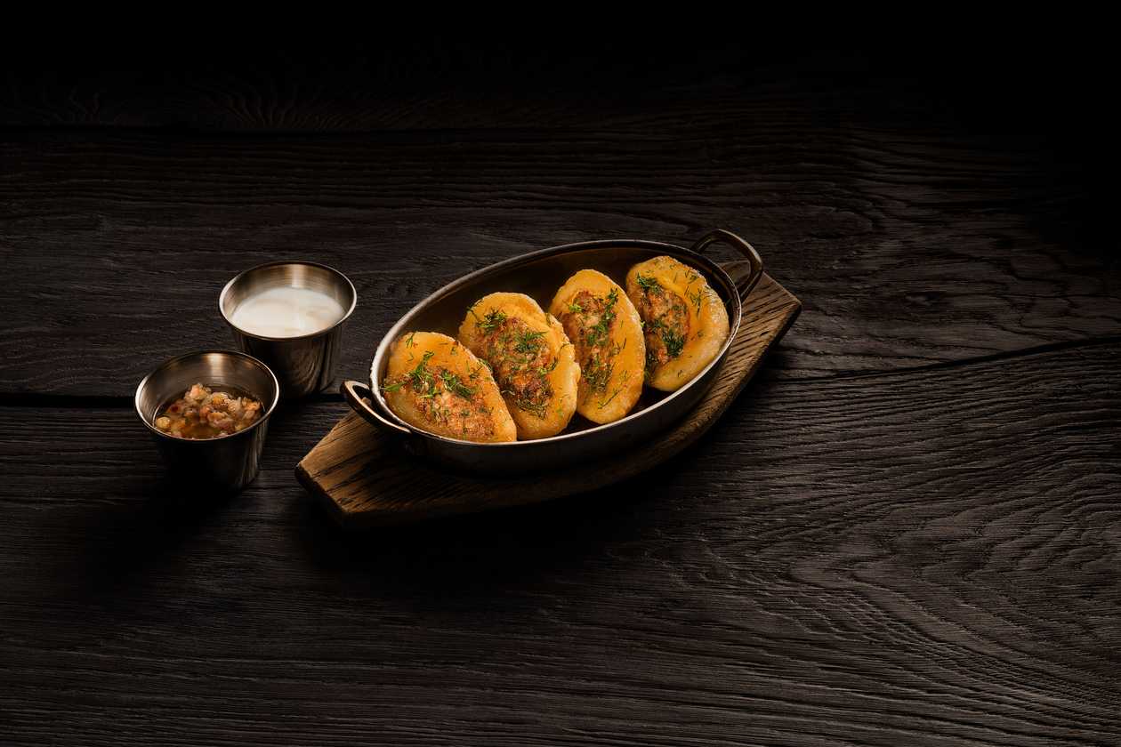 Fried dumplings stuffed with meat with crackling sauce and sour cream