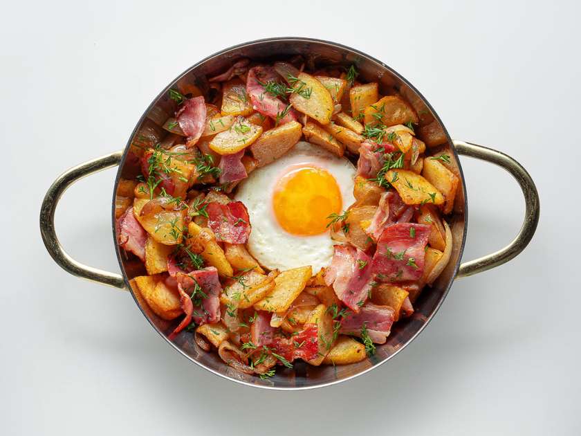 Пательня з яєчнею, смаженою картоплею та беконом