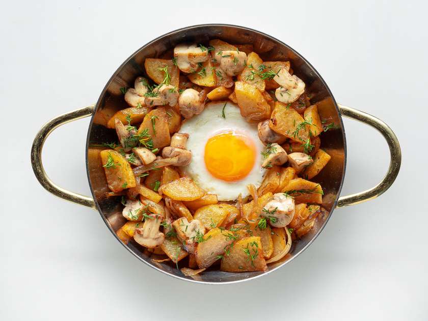 Пательня з яєчнею, смаженою картоплею та грибами