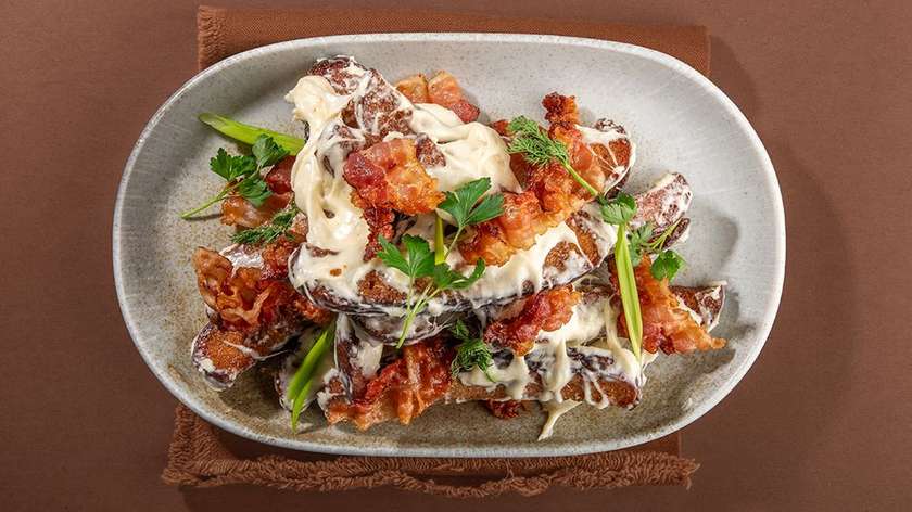 Deep-fried bread with cheese sauce and crispy bacon