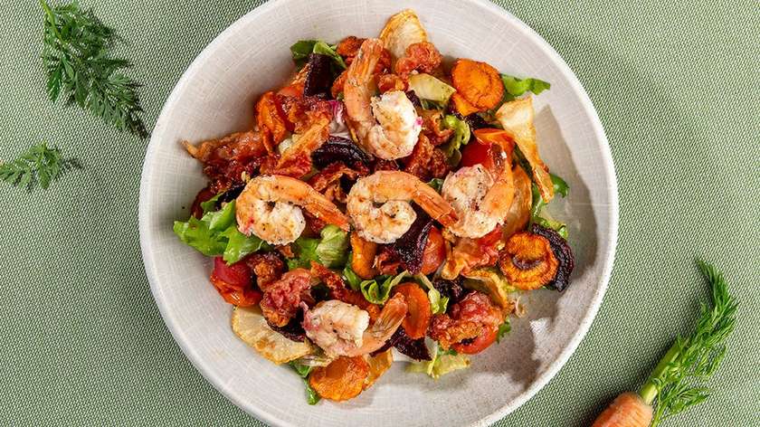 Fried root vegetable salad with crispy bacon and prawns
