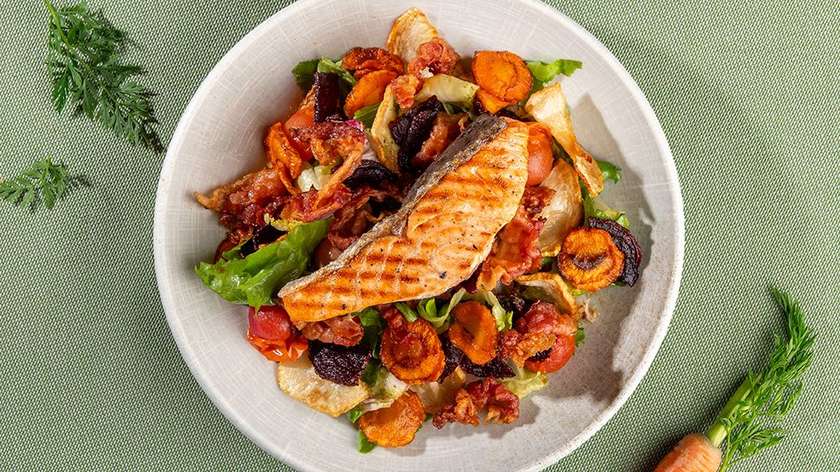 Fried root vegetable salad with crispy bacon and fried salmon