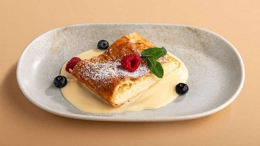 Homemade strudel with cottage cheese and warm vanilla sauce
