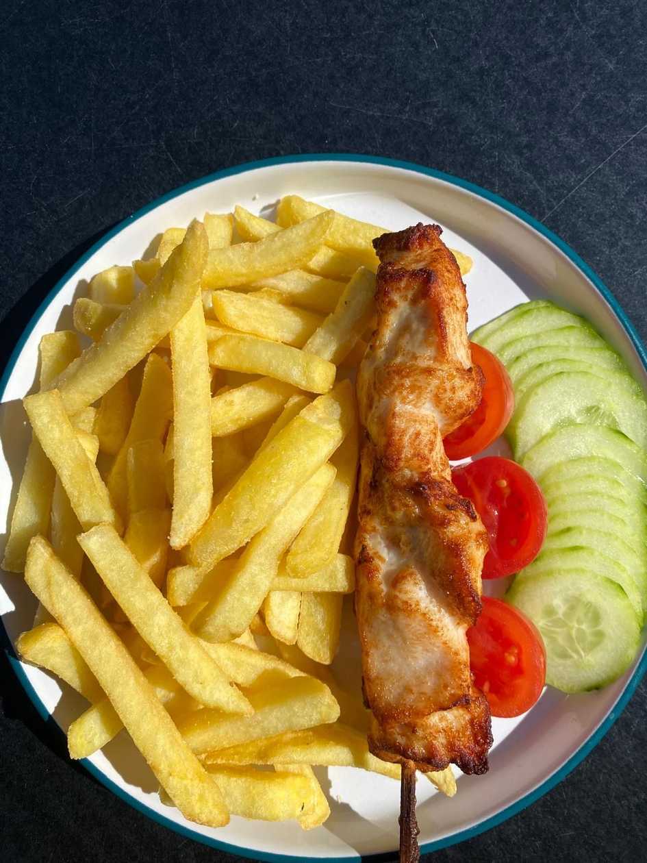Chicken fillet on a skewer with french fries