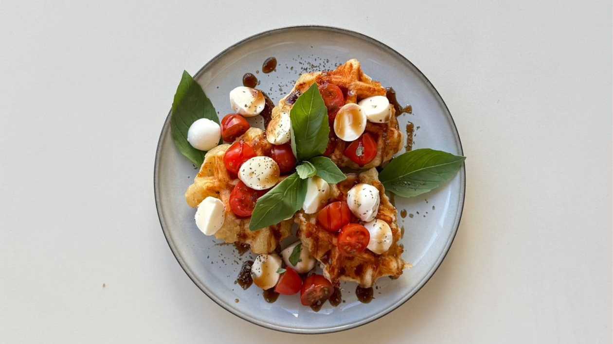 Cheese waffle bites with mozzarella, cherry tomatoes and balzamico glaze