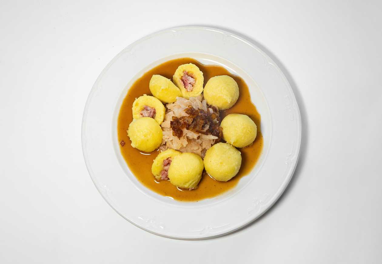 Potato dumplings stuffed with smoked meat, sauerkraut, onion
