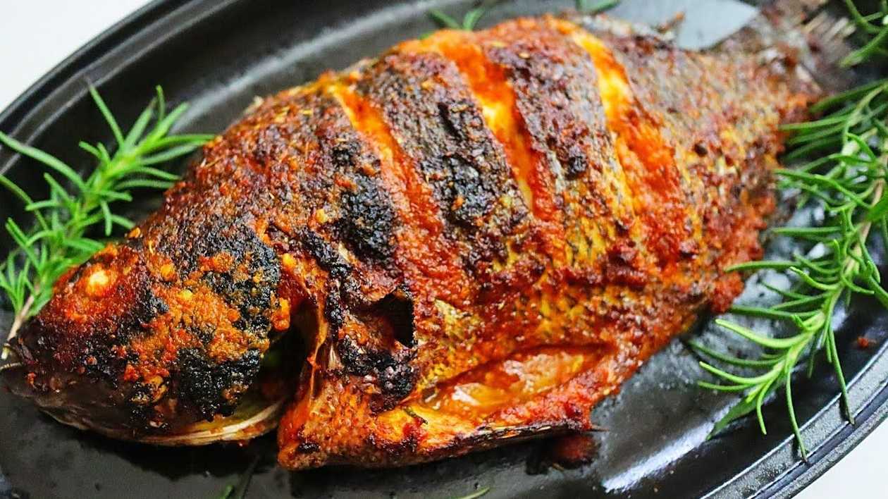Grilled tilapia served with 2 fried eggs and vegetables chilling pepper (full tilapia)