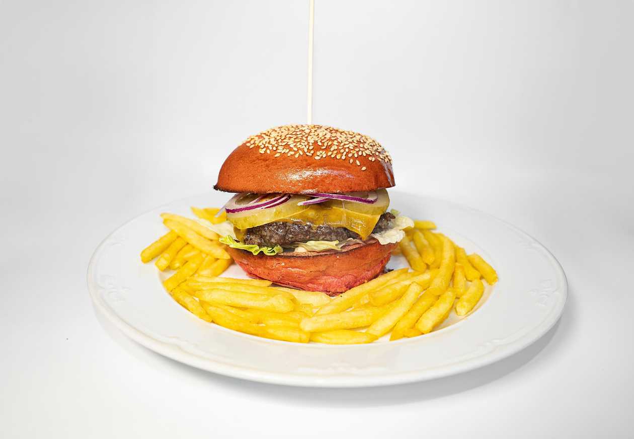Beef cheeseburger with BBQ sauce, mayonnaise, tomato, onion, salad and cheddar, french fries