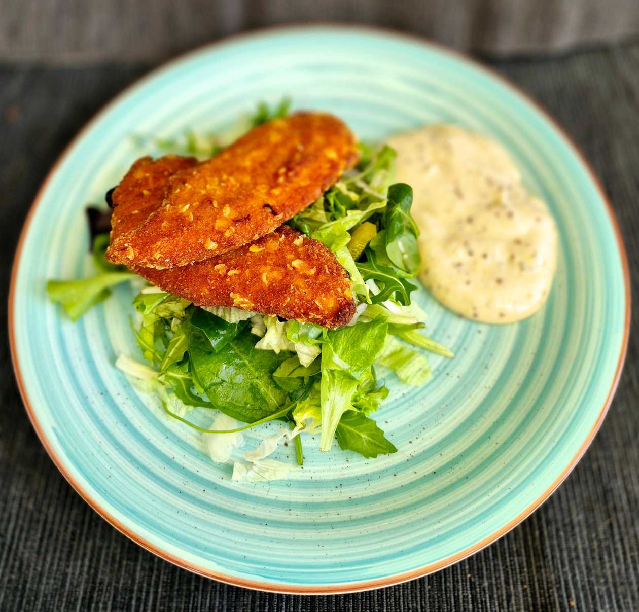 Spicy mini chicken schnitzels with mixed salad and caper mayonnaise