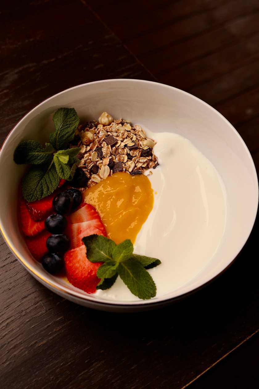 Granola z jogurtem greckim, musem mango i owocami