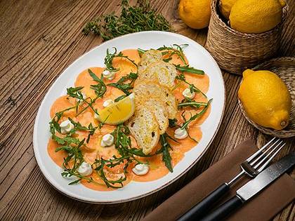 Salmon carpaccio with feta, arugula and orange sauce