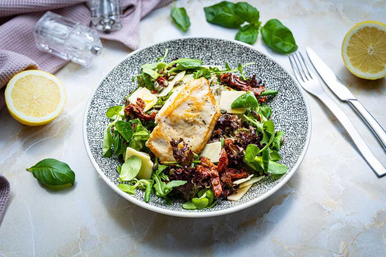 Salat grillitud kana, parmesani, päikesekuivatatud tomatite ja röstitud kõrvitsaseemnetega