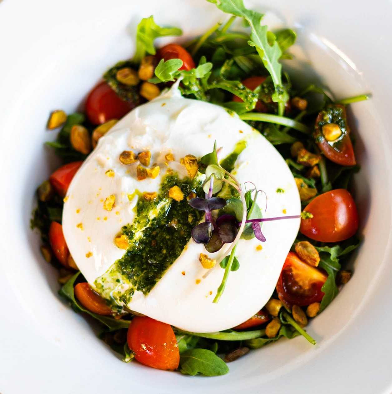 Burrata Salad with Cherry Tomatoes, Basil Pesto, Arugula, and Pistachios