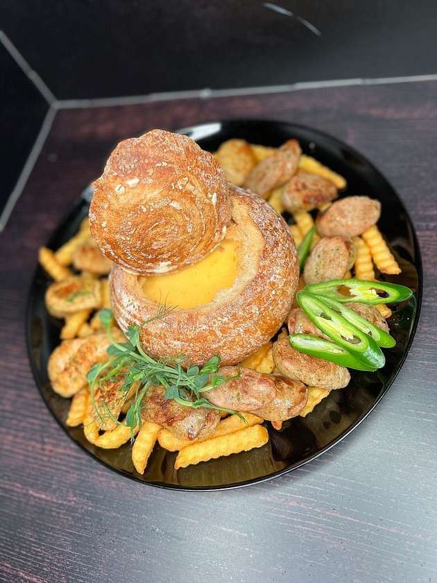 Chef's signature sausages in a cheese bath
