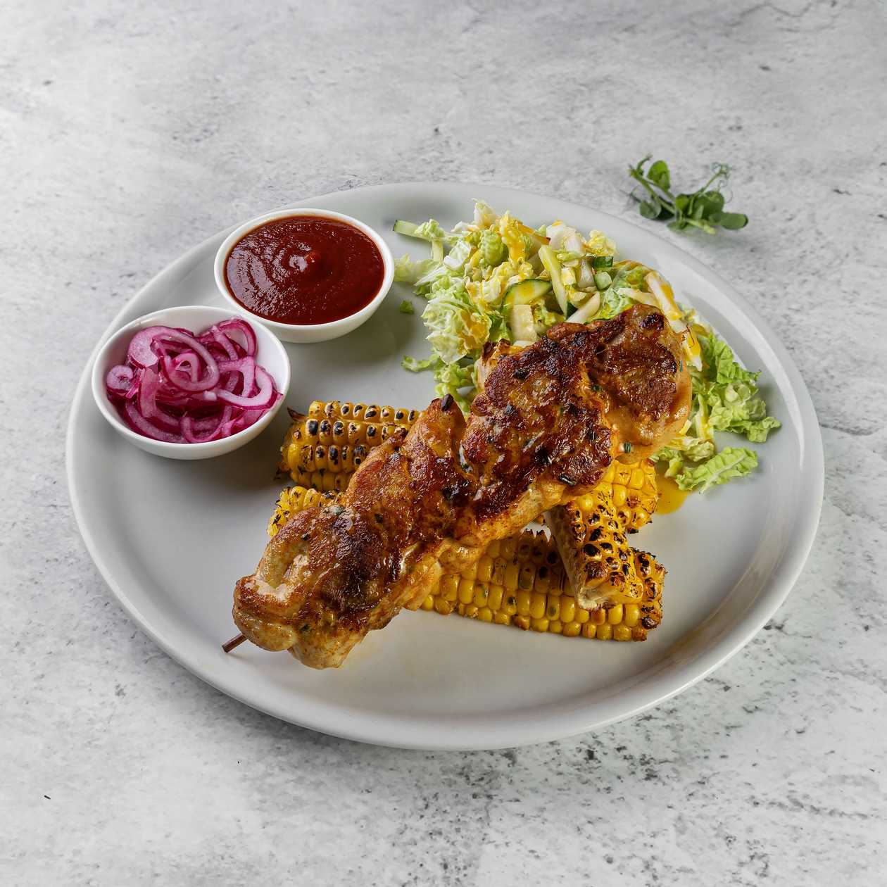 Chicken shashlik with corn "ribs", fresh salad, pickled onions and ketchup