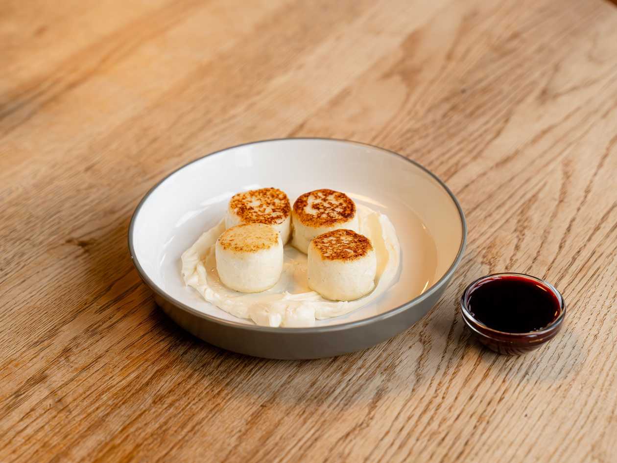 Tender syrniki with ricotta cream and berry sauce