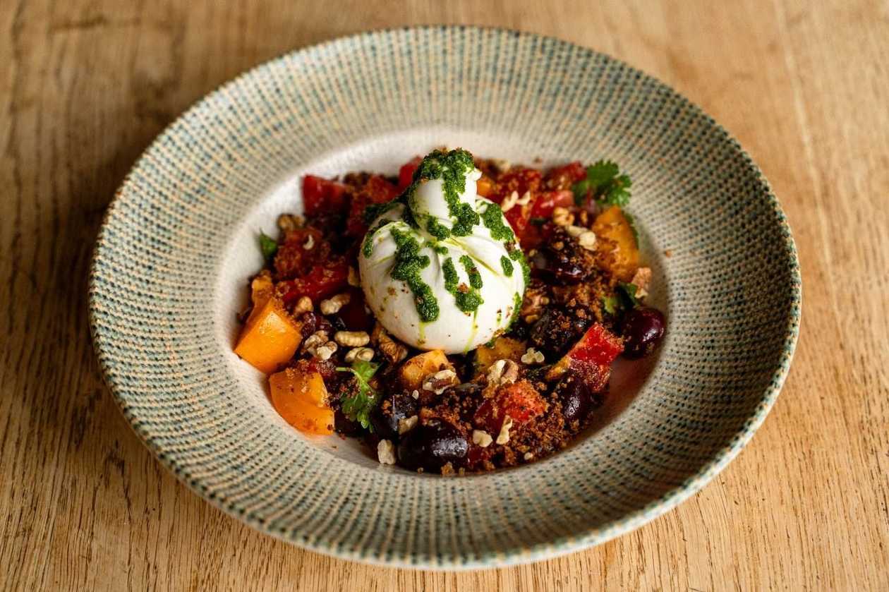 Tender farmer's burrata with a mix of tomatoes and marinated seasonal berries