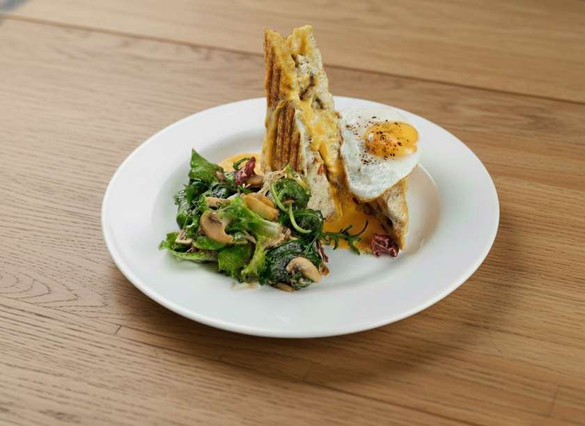 Croque Madame with cheese sause and salad