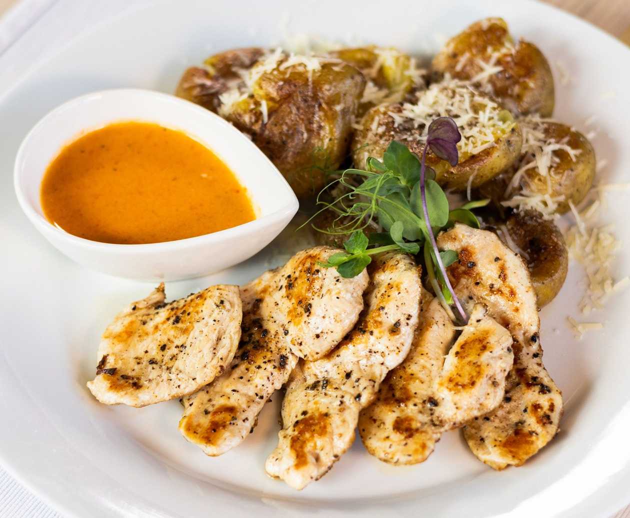 Grilled chicken medallions with roasted parmesan grenaille potatoes and roasted pepper sauce
