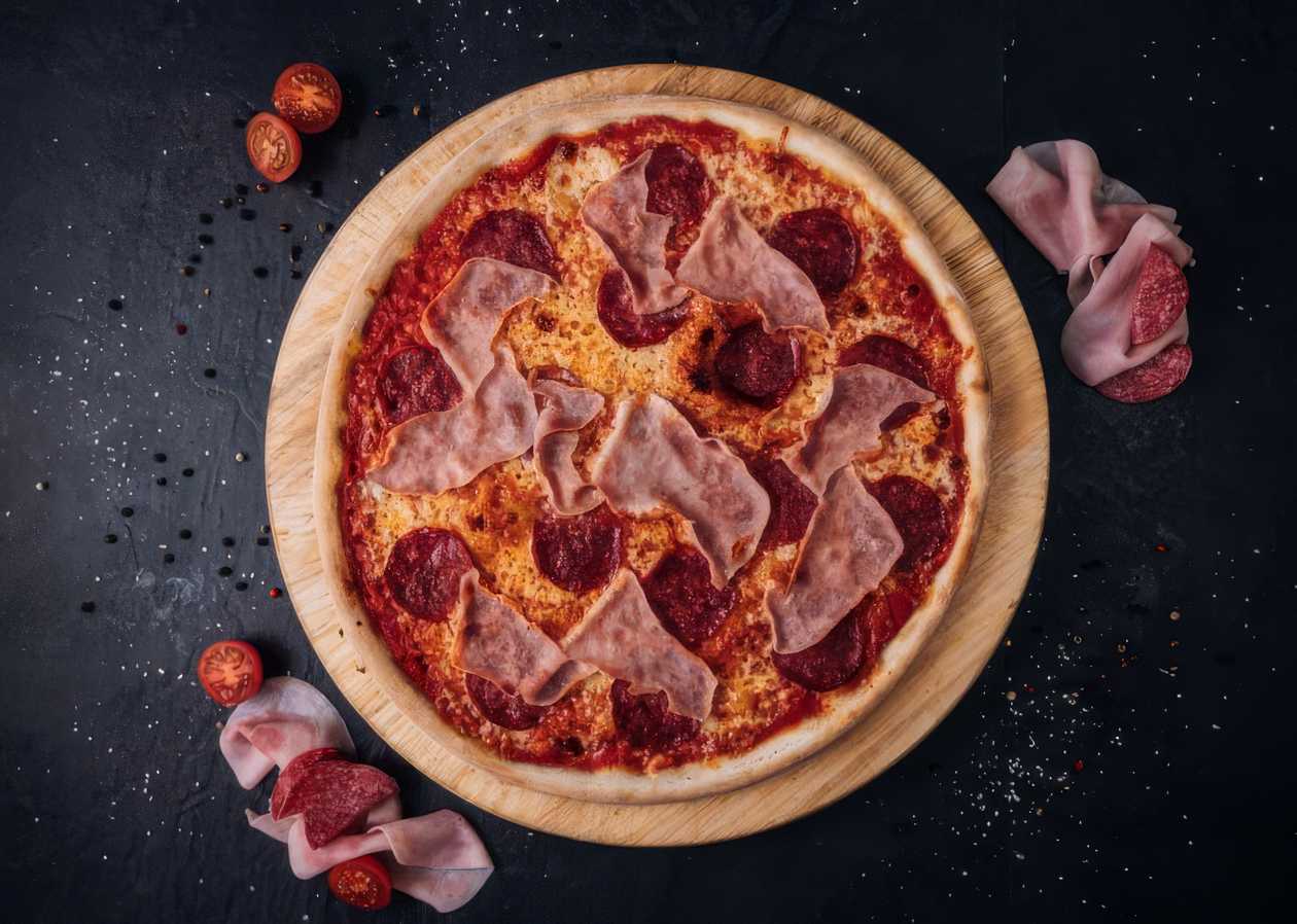 Gluten-free pizza with ham and salami