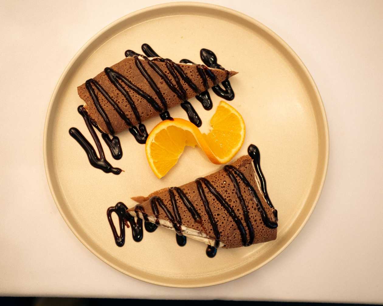 Black crepes with mascarpone, cottage cheese, and chocolate sauce